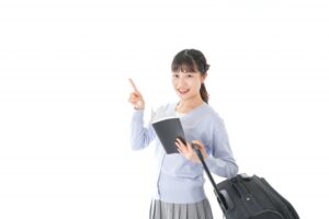 ガイドブックを持ち一人旅をする若い女性