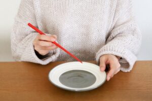 食卓で箸を持つ女性