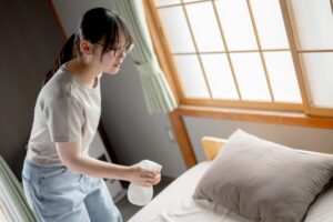 スプレーを使う若い女性