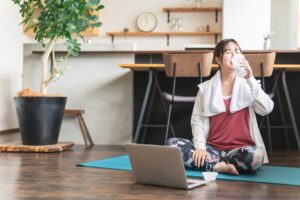 トレーニング後にプロテインを飲む若い女性