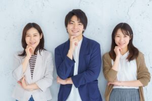 笑顔でこちらを見る3人のビジネスパーソン