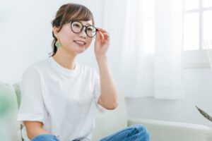 ソファに座るメガネをかけたアジア人女性