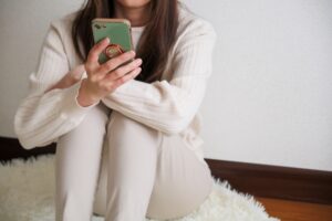 座ってスマホを見る女性